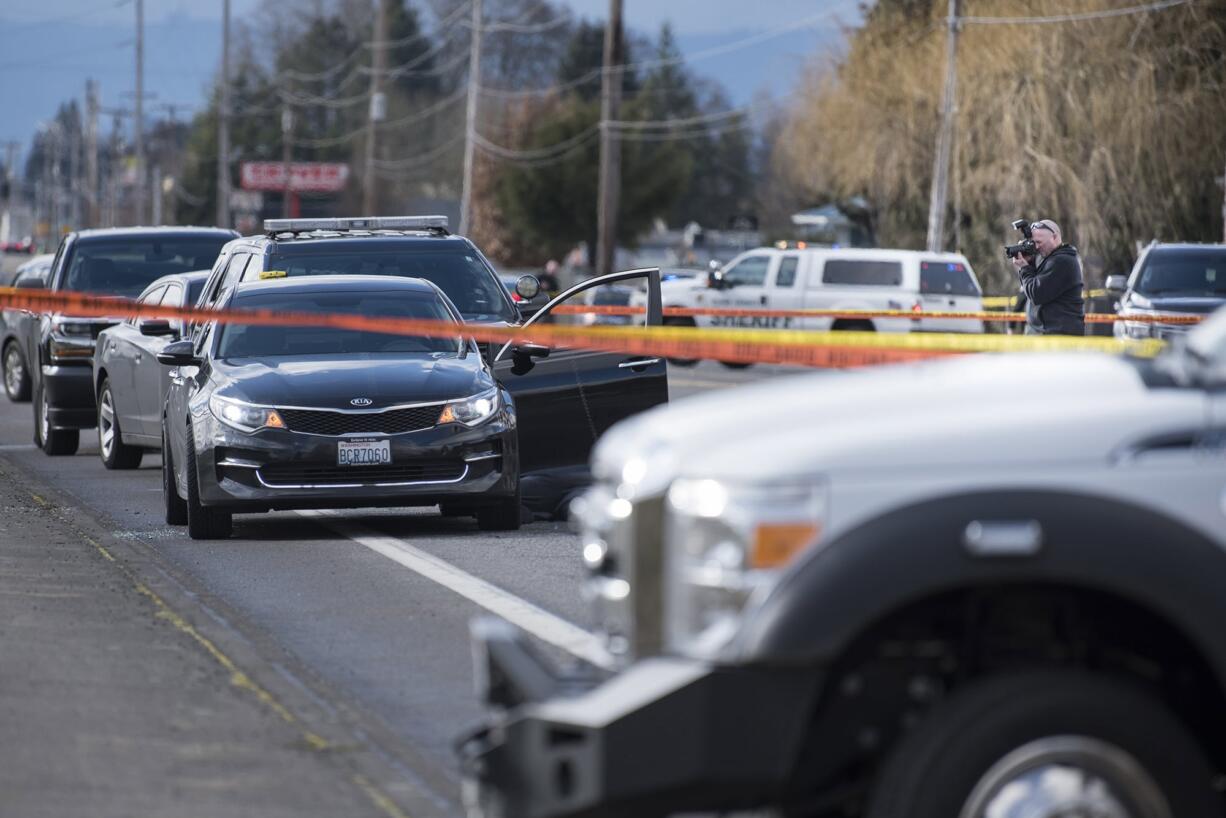 An investigator photographs the scene of a police shooting in Hazel Dell on Thursday, March 7, 2019.