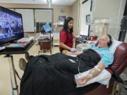 Phlebotomist Sotheary Chet, center, works with platelet donor John Reinhardt of Battle Ground at the American Red Cross Blood Donor Center in Vancouver. Reinhardt, a regular platelet donor, decided to watch “Crazy Rich Asians” over the two-hour donation process. Platelets, which have a shelf life of five days, are mainly used for trauma injuries.