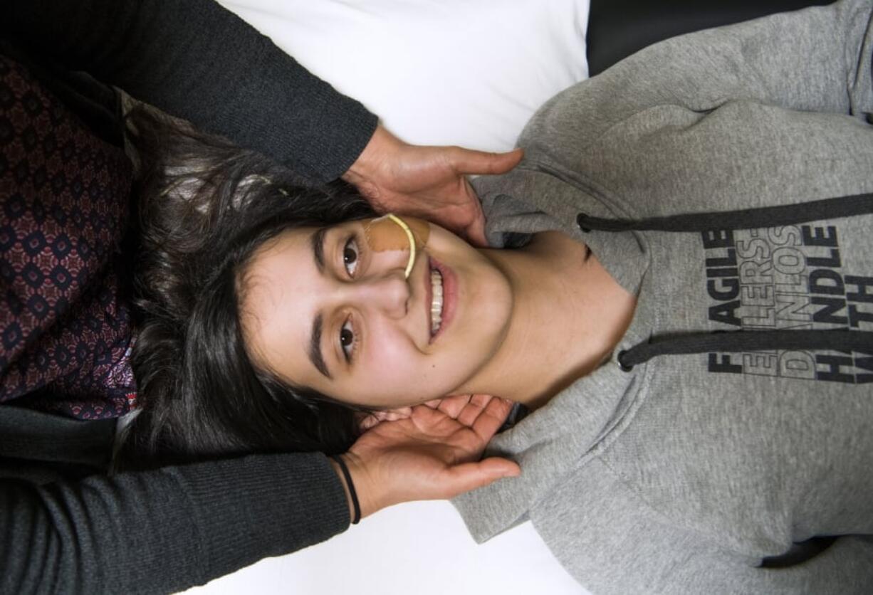 Physical therapist Chie Tadaki works on alignment with Addison Holler of Woodland, 14, during her appointment at Good Health Physical Therapy in Portland. Addison’s sweatshirt reads, “Fragile — Ehlers-Danlos — handle with care.” Addison has Ehlers-Danlos, a disease that weakens the connective tissue in her body, and makes her joints frequently dislocate.