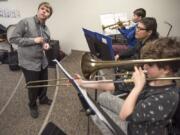 Music teacher Shane Dittmar of the Washington State School for the Blind, left, listens carefully as beginning band students Jaymes Gummere (in back), Xavier Lopez and Olivia McGraw work on scales and rhythms.