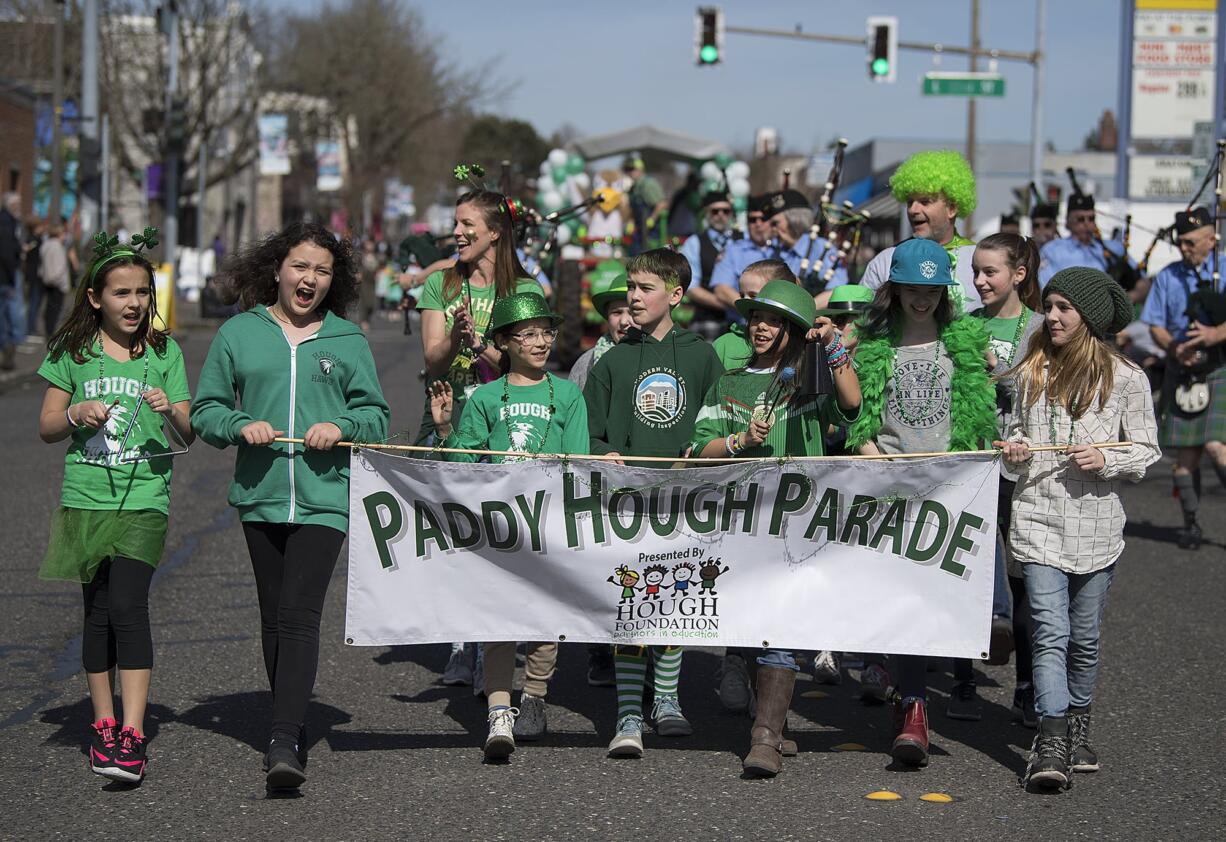 Students from Hough Elementary School greet spectators in Uptown Village while leading the annual Paddy Hough Parade on Friday afternoon, March 15, 2019.