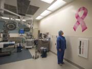 Operating room manager Jen Walling looks at a newly painted pink ribbon in a Legacy Salmon Creek Medical Center operating room. The operating room frequently has breast cancer surgeries in it, and the pink ribbon, which has the word “hope” painted on it, is a positive symbol for breast cancer patients.