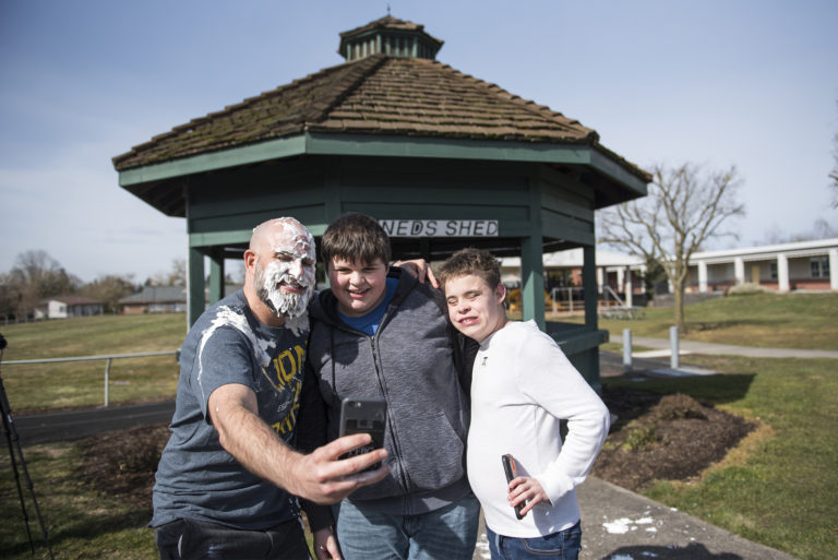 Scott McCallum, superintendent of the Washington State School for the Blind, from left, poses for a selfie with Freshman Deegan Richardson and Eighth Grader Fenix Roarke after McCallum took a pie to the face as a reward for students who memorized 50 digits of Pi at the Washington State School for the Blind on Thursday afternoon, March 14, 2019.