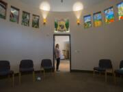 Support services coordinator Erin Orren pauses in the doorway of the Seasons of Hope Room as colorful stained glass windows are seen overhead at Community Home Health & Hospice’s Seasons of Hope Grief Center in Salmon Creek. The stain-glass windows were made by Portland artist David Schlicker.