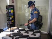 Trooper Shane Kesler lays out bump stocks that have been collected during a bump stock buyback event hosted by Washington State Patrol in Vancouver. Leading up to the federal ban that takes effect on March 26, owners of bump stocks can turn them in to the Washington State Patrol for a $150 each.