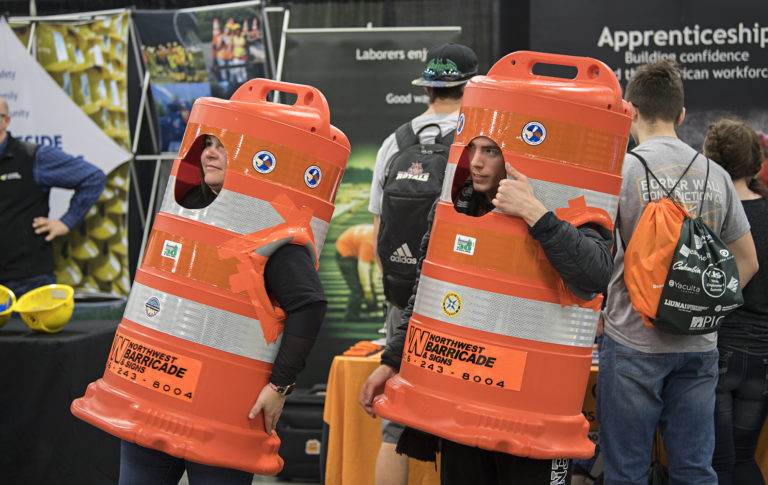 Christina Riley of Laborers' International Union of North America, left, and Joey Schiro, 19, of Legacy High School greet fellow job fair participants while dressed as construction barricades at the Clark County Events Center on Tuesday morning, March 19, 2019.