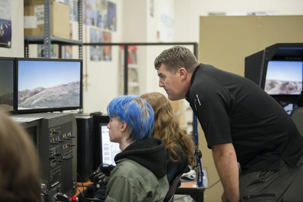 Junior Seth Trimbo, 16, takes a seat behind the wheel of a flight simulator as aviation technology instructor Robert Reinebach offers assistance. The Cascadia Tech Academy aviation program has 92 students enrolled from 10 Clark County school districts.