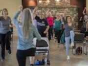 Participants in an EnhanceFitness class keep in step with instructor Laurie Porter while working out at Battle Ground Community Center. The class provides free group exercise for people 60 and older.