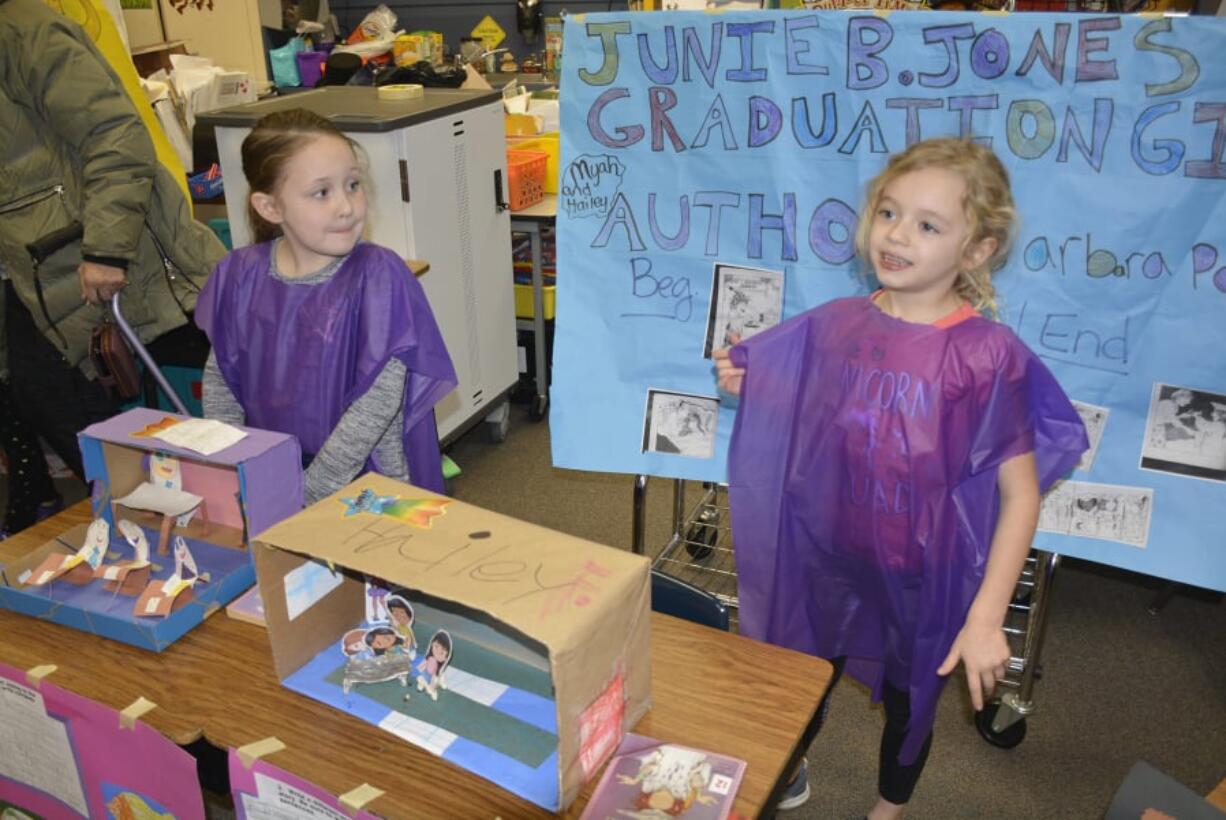 Washougal: Gause Elementary School first-graders Myah White, left, and Hailey Faught with their posters and dioramas for the school’s book party.