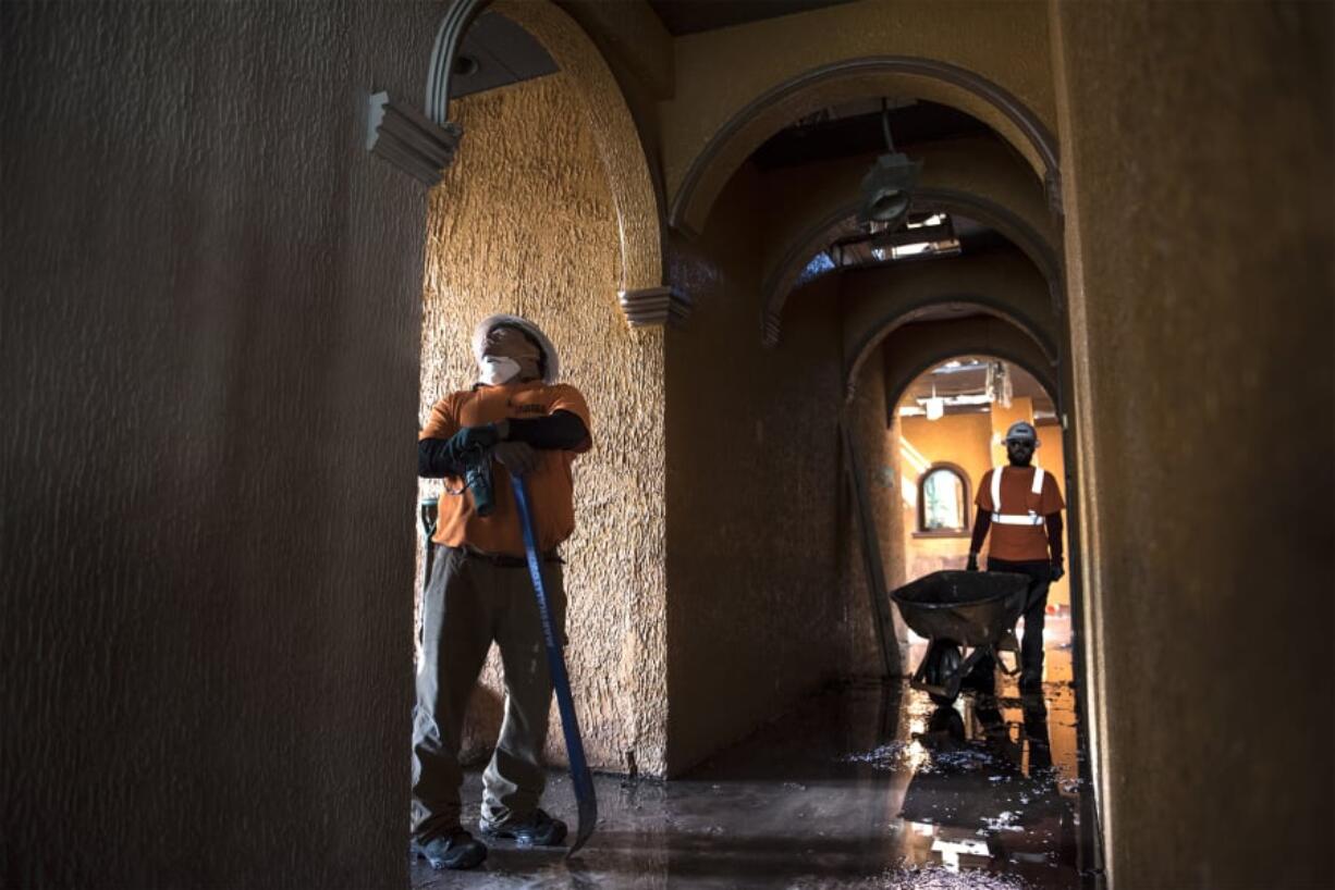 Yair Rios, left, and Brandon Taber with Laneco Inc. clear out the former El Presidente building on the Providence Academy grounds on Tuesday afternoon. The demolition process is expected to take three weeks.