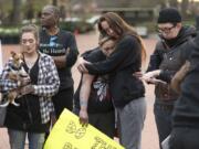 Tiffini Dillard hugs Mollie Wickenhagen during a march Tuesday in downtown Vancouver. Michael Pierce, the father of Wickenhagen’s daughter, was shot and killed Feb. 28 by Vancouver police.