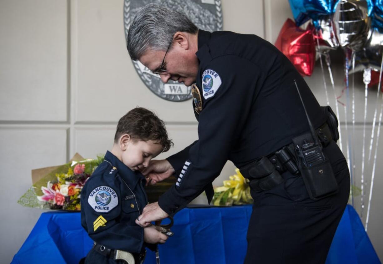 Clayton Jones, 4, is sworn in as an official police officer by Vancouver Police Chief James McElvain at the department’s east precinct late Friday afternoon. Clayton was diagnosed with terminal cancer in 2017 and has since developed a bond with the Vancouver Police Department.