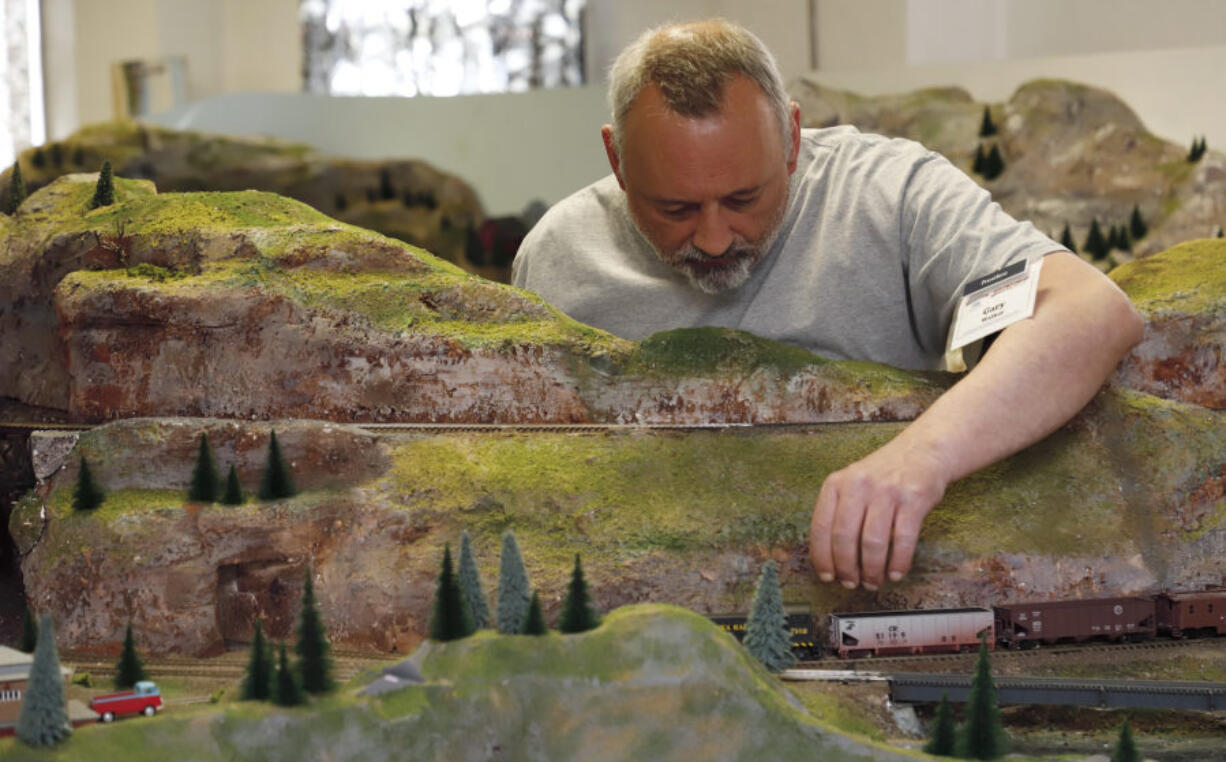 Gary Walker, president of the Southwest Washington Model Railroaders, tinkers with a train Saturday at the club’s open house in the basement of Memorial Lutheran Church in Rose Village.