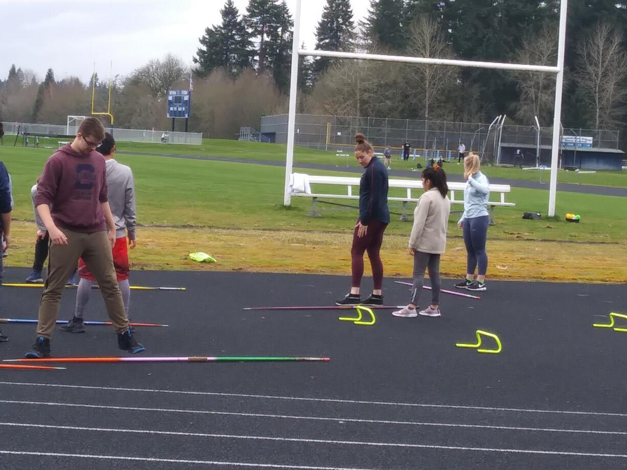 Olympic javelin thrower and Skyview High alum Kara Winger (center in blue top) discusses footwork technique with javelin throwers at Skyview's practice on Friday (Tim Martinez/The Columbian)