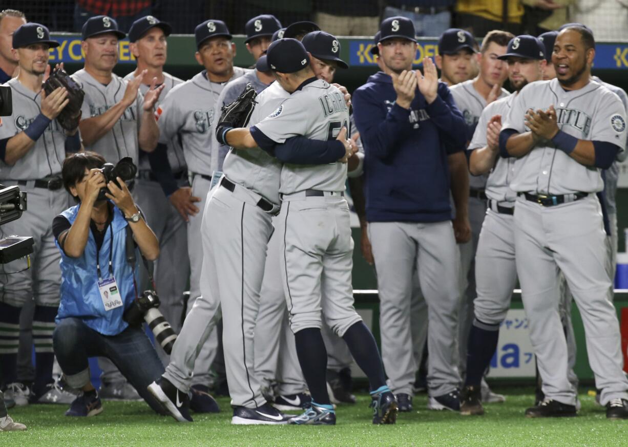 Seattle Mariners right fielder Ichiro Suzuki, center, is applauded by teammates at the bench after leaving the field for defensive substitution in the eighth inning of Game 2 of their Major League baseball opening series at Tokyo Dome in Tokyo, Thursday, March 21, 2019.