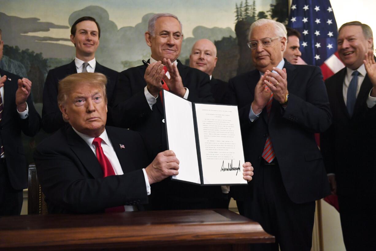 President Donald Trump holds up a signed proclamation recognizing Israel's sovereignty over the Golan Heights, as Israeli Prime Minister Benjamin Netanyahu looks on in the Diplomatic Reception Room of the White House in Washington, Monday, March 25, 2019.