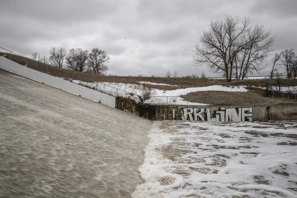 In this Monday, March 25, 2019 photo, water flows over the spillway at White Clay Dam near Pine Ridge, S.D., on the Pine Ridge Indian Reservation following spring flooding.