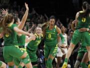 Oregon guard Sabrina Ionescu, left, and Oregon forward Satou Sabally, right, celebrate a regional final victory over Mississippi State in the NCAA women's college basketball tournament Sunday, March 31, 2019, in Portland, Ore. Oregon defeated Mississippi State 88-84.