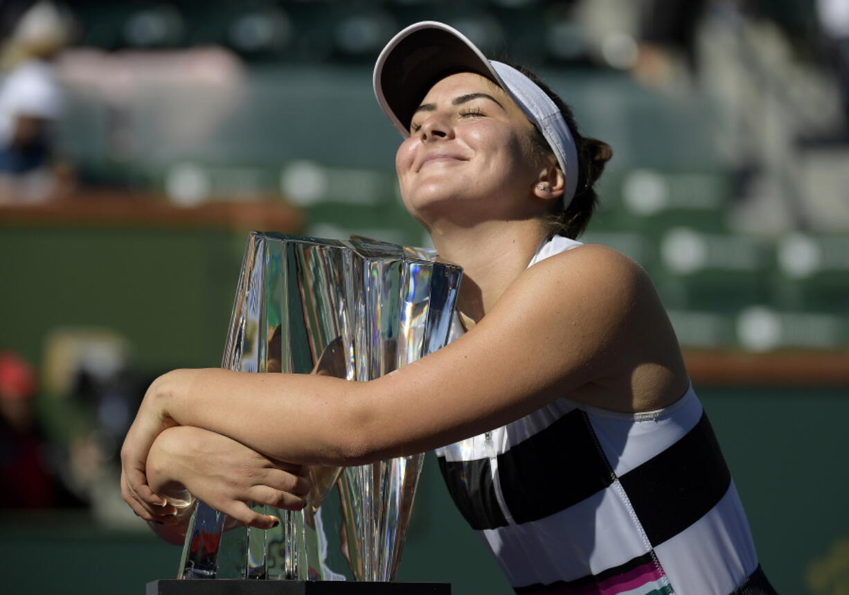 Bianca Andreescu, of Canada, smiles as she hugs her trophy after defeating Angelique Kerber, of Germany, in the women’s final at the BNP Paribas Open tennis tournament Sunday, March 17, 2019, in Indian Wells, Calif. Andreescu won 6-4, 3-6, 6-4. (AP Photo/Mark J.