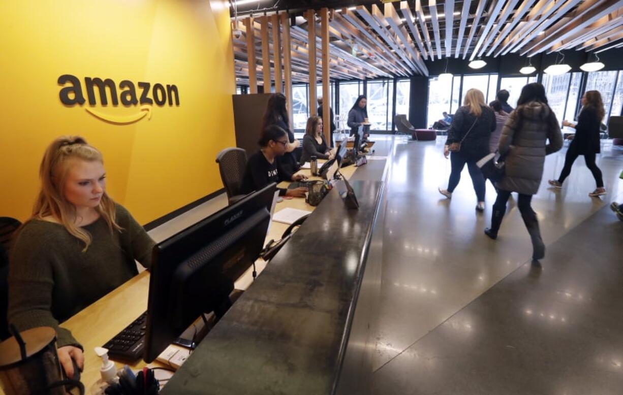 Employees walk through a lobby at Amazon’s headquarters in Seattle.