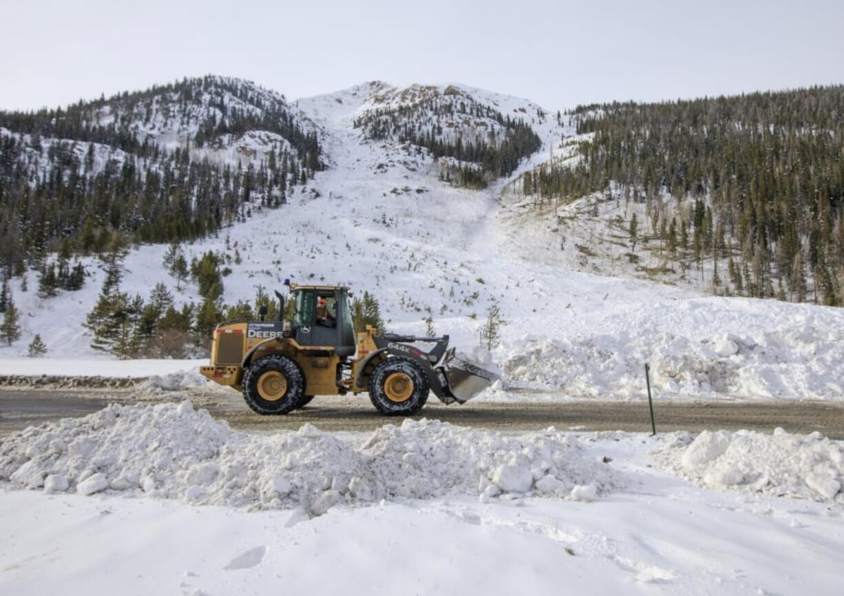 FILE - In this March 5, 2019 file photo, crews work to remove the snow debris from a controlled avalanche that spilled onto Interstate 70 near Loveland Pass, Colo. Historic avalanche conditions persisted in the mountains of Colorado on Thursday, March 7, 2019, shutting down portions of I-70 and prompting a rare warning for drivers to avoid traveling through the region that’s home to many ski resorts.