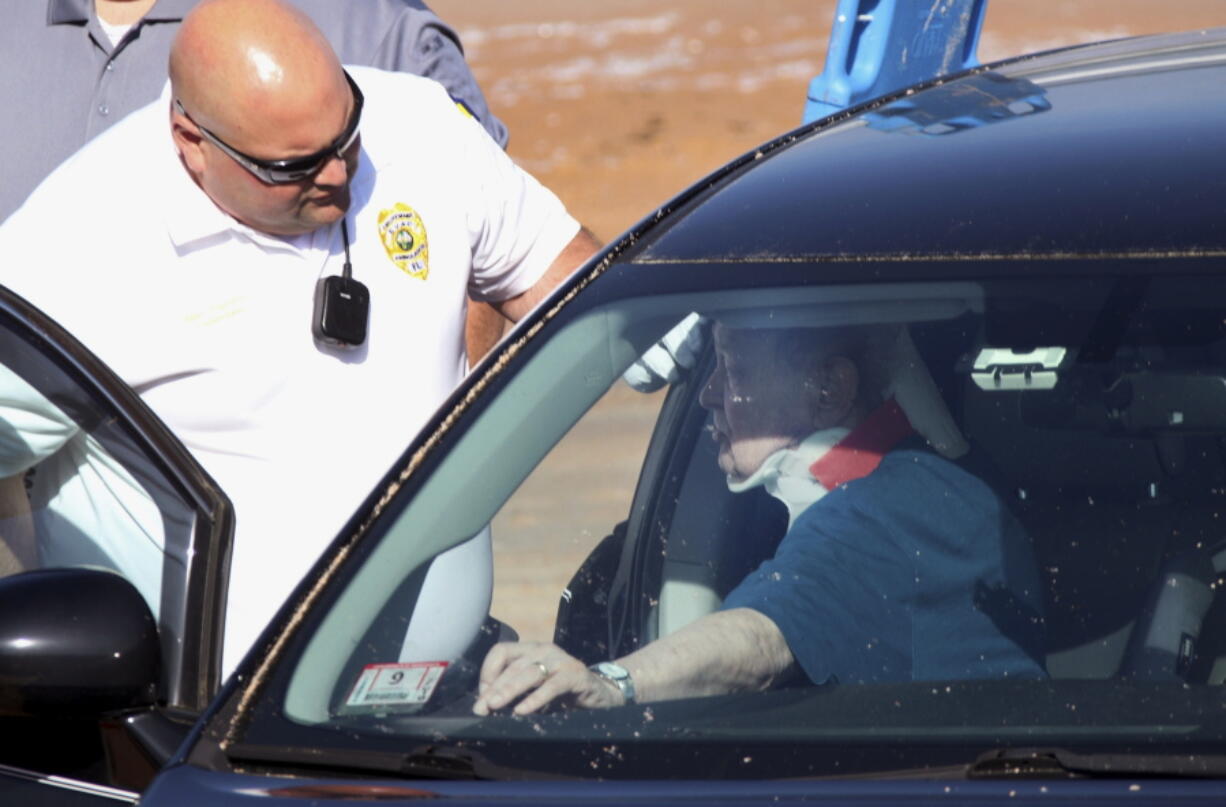 In this Wednesday, March 20, 2019 photo, rescue workers assist 82-year-old William Johnson after his vehicle hit a wooden barrier separating a parking lot from the beach and hit four children at Ormond-by-the-Sea, Fla. Three children and Johnson were taken by ambulance to a nearby hospital. A 5-year-old suffered traumatic injuries and was airlifted to another hospital.