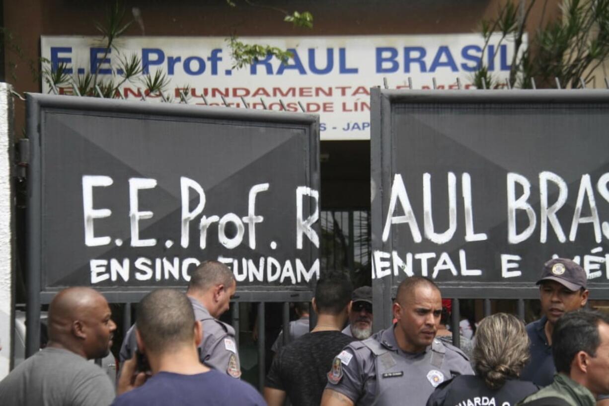 Police officers guard the entrance of the Raul Brasil State School in Suzano, Brazil, Wednesday, March 13, 2019. The state government of Sao Paulo said two teenagers, armed with guns and wearing hoods, entered the school and began shooting at students. They then killed themselves, according to the statement.