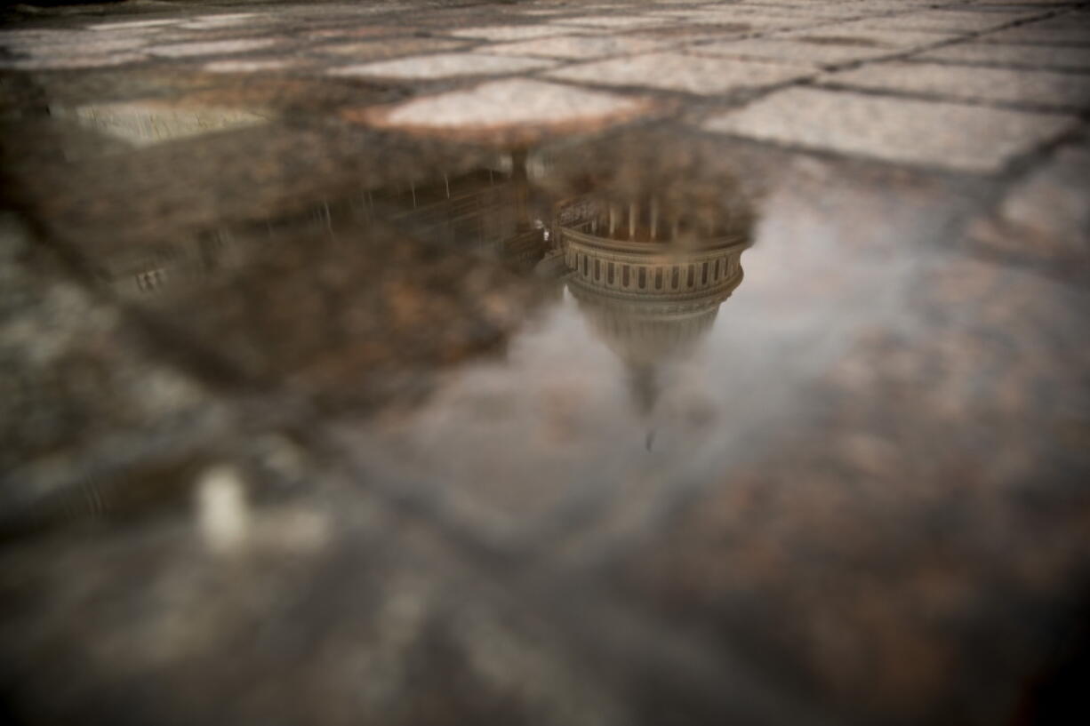 FILE- In this Feb. 22, 2019, file photo the dome of the U.S. Capitol Building is visible in reflection in Washington. On Friday, March 22, the Treasury Department releases federal budget data for February.