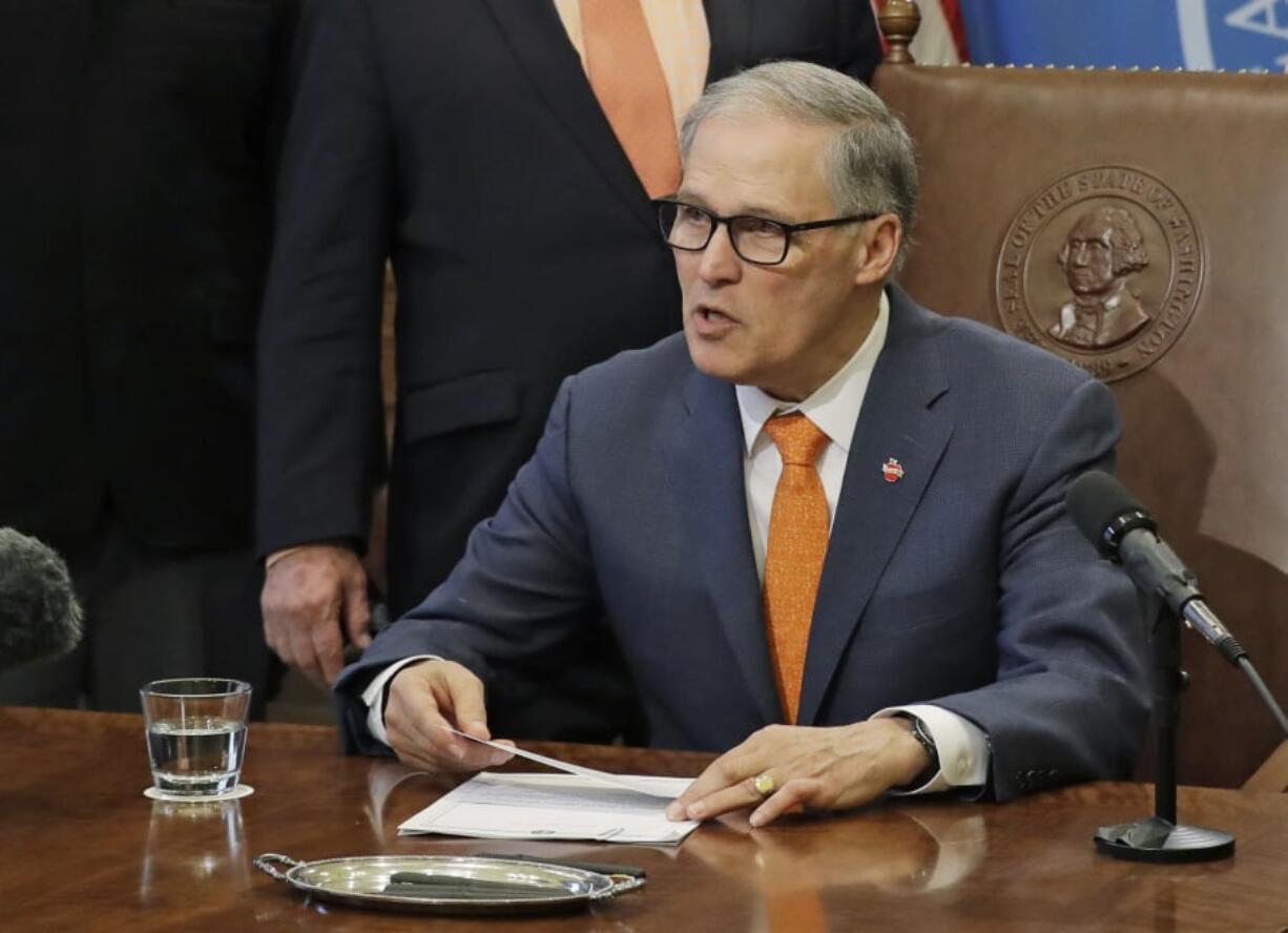 Washington Gov. Jay Inslee speaks Thursday before signing a bill funding gun bump stock buybacks in the state at the Capitol in Olympia. Legislators banned the devices in 2018 and created the buyback program at the same time, but left it unfunded. Bump stocks allow a semiautomatic rifle to fire nearly continuously allowing the gun’s trigger to ‘bump’ rapidly against the user’s finger. (AP Photo/Ted S.