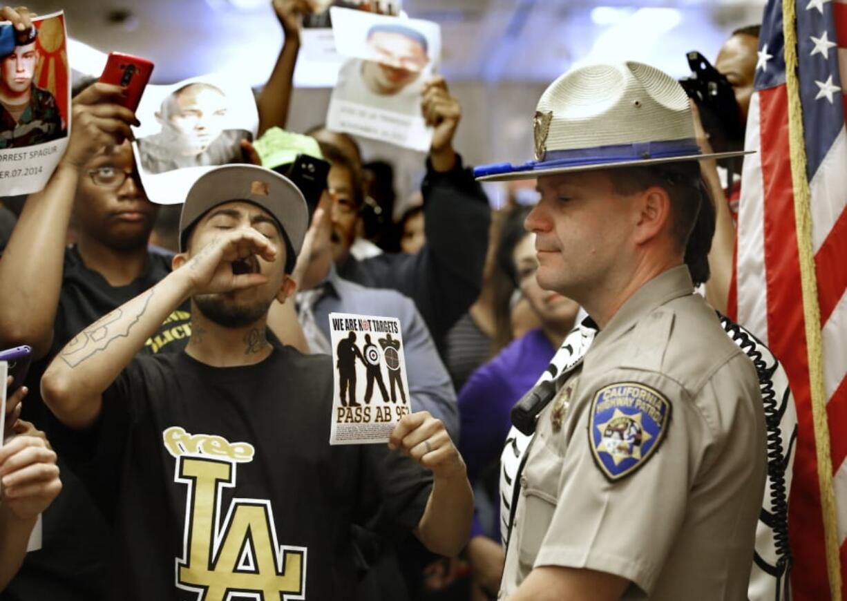 California Highway Patrol Officer J. Nelson stands Sept. 2, 2015, outside the governor’s office as protesters block the hallway while demanding the passage of AB953 in Sacramento, Calif.