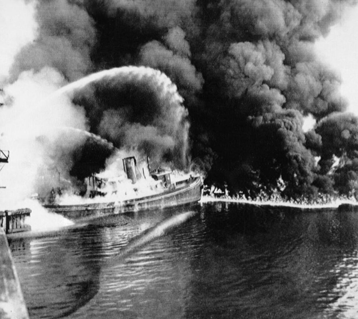 FILE - In this June 25, 1952 file photo, a fire tug fights flames on the Cuyahoga River near downtown Cleveland. Federal environmental regulators say fish living in the northeastern Ohio river are now safe to eat. The easing of fish consumption restrictions on the Cuyahoga River was lauded by Republican Gov.