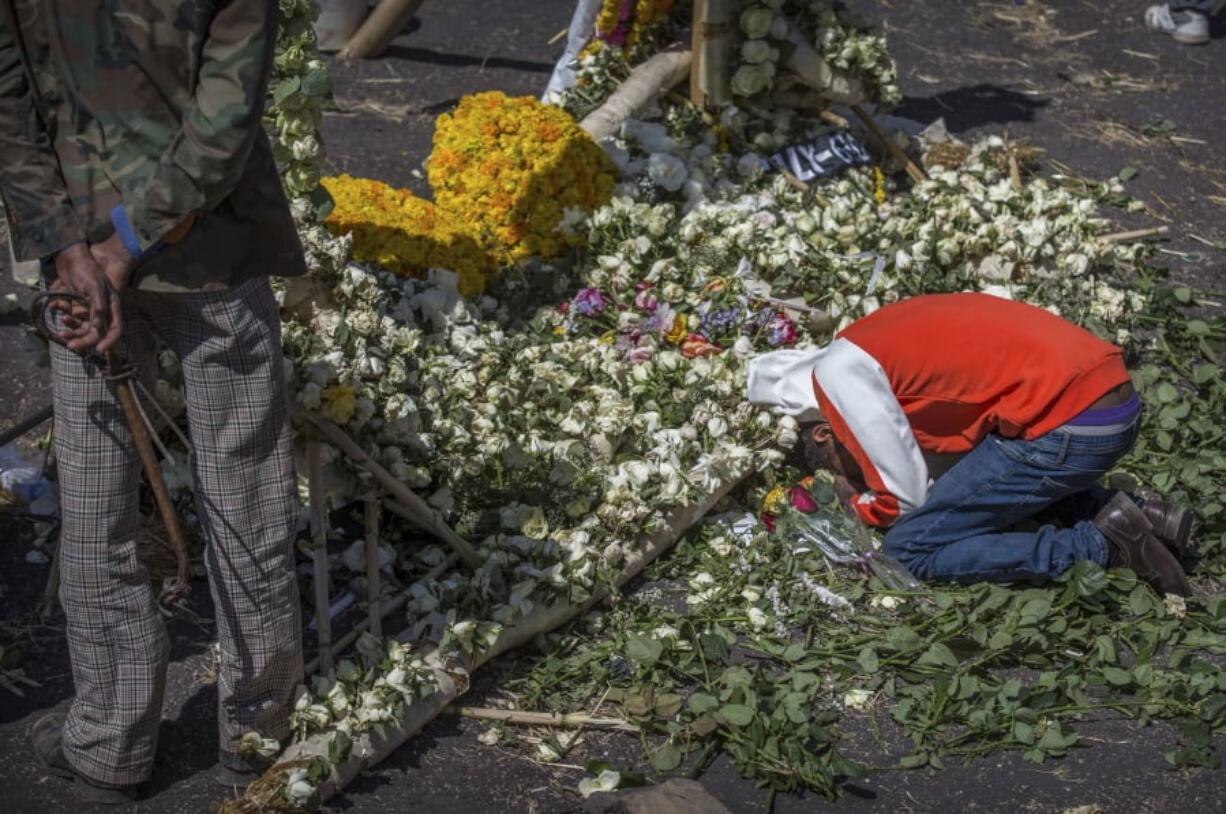 An Ethiopian relative of a crash victim mourns and grieves next to a floral tribute at the scene where the Ethiopian Airlines Boeing 737 Max 8 crashed shortly after takeoff on Sunday killing all 157 on board, near Bishoftu, south-east of Addis Ababa, in Ethiopia Friday, March 15, 2019. Analysis of the flight recorders has begun in France, the airline said Friday, while in Ethiopia officials started taking DNA samples from victims’ family members to assist in identifying remains.