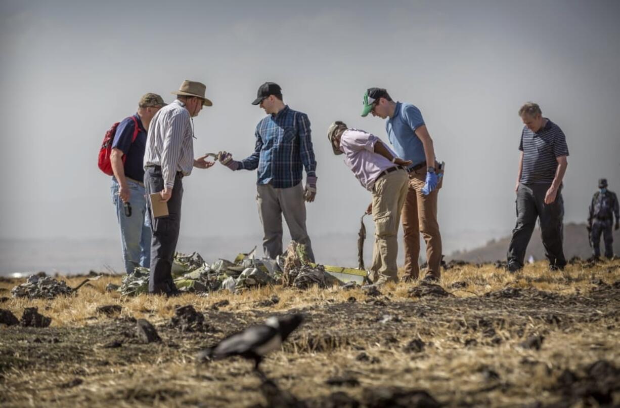 Foreign investigators examine wreckage at the scene where the Ethiopian Airlines Boeing 737 Max 8 crashed shortly after takeoff on Sunday killing all 157 on board, near Bishoftu, or Debre Zeit, south of Addis Ababa, in Ethiopia Tuesday, March 12, 2019. Ethiopian Airlines had issued no new updates on the crash as of late afternoon Tuesday as families around the world waited for answers, while a global team of investigators began picking through the rural crash site.