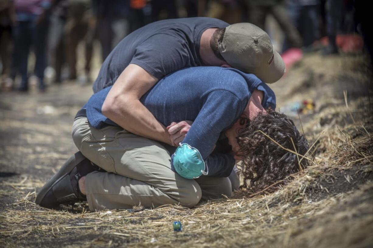 Relatives react at the scene where the Ethiopian Airlines Boeing 737 Max 8 crashed shortly after takeoff on Sunday killing all 157 on board, near Bishoftu, south of Addis Ababa, in Ethiopia Wednesday, March 13, 2019. The black box from the Boeing jet that crashed will be sent overseas for analysis but no country has been chosen yet, an Ethiopian Airlines spokesman said Wednesday, as much of the world grounded or barred the plane model and grieving families arrived at the disaster site.