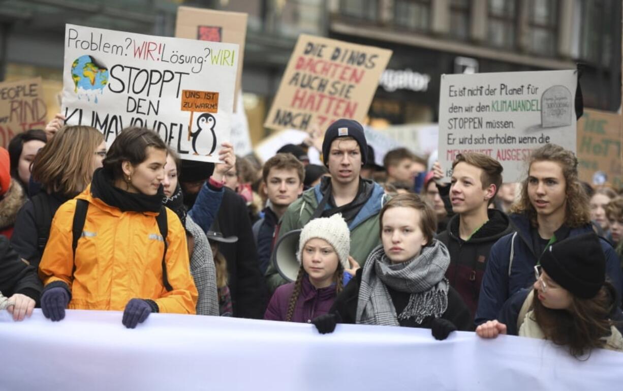 Swedish climate activist Greta Thunberg, front with white cap, attends a protest rally in Hamburg, Germany, Friday, March 1, 2019.