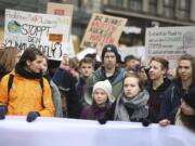 Swedish climate activist Greta Thunberg, front with white cap, attends a protest rally in Hamburg, Germany, Friday, March 1, 2019.