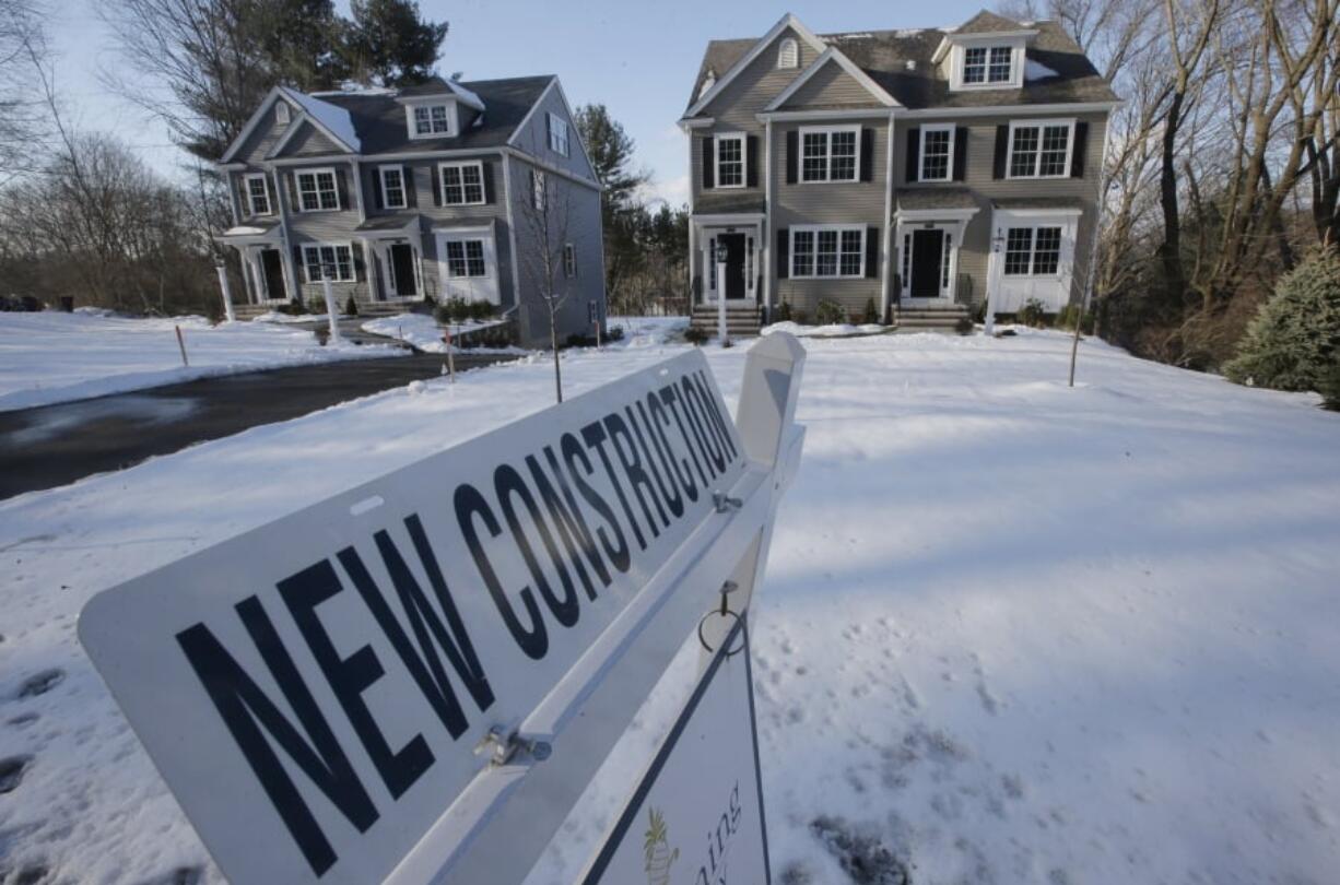 In this Thursday, Feb. 21, 2019 photo a newly constructed homes sit near a sign, in Natick, Mass. On Friday, March 8, the Commerce Department reports on U.S.