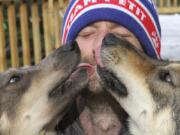 This Wednesday, March 20, 2019, photo shows Iditarod musher Nicolas Petit getting kisses from two of his dogs in Anchorage, Alaska. The Frenchman was in the lead of this year’s race but his dog team quit running after Petit yelled at Joey, left, to stop picking on Danny, right. Petit says that isn’t the reason the dogs quit running; instead, they quit about the same point the team got lost in a blizzard in the 2018 race.