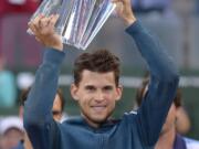 Dominic Thiem, of Austria, raises a trophy over his head after defeating Roger Federer, of Switzerland, in the men’s final at the BNP Paribas Open tennis tournament Sunday, March 17, 2019, in Indian Wells, Calif. Thiem won 3-6, 6-3, 7-5. (AP Photo/Mark J.