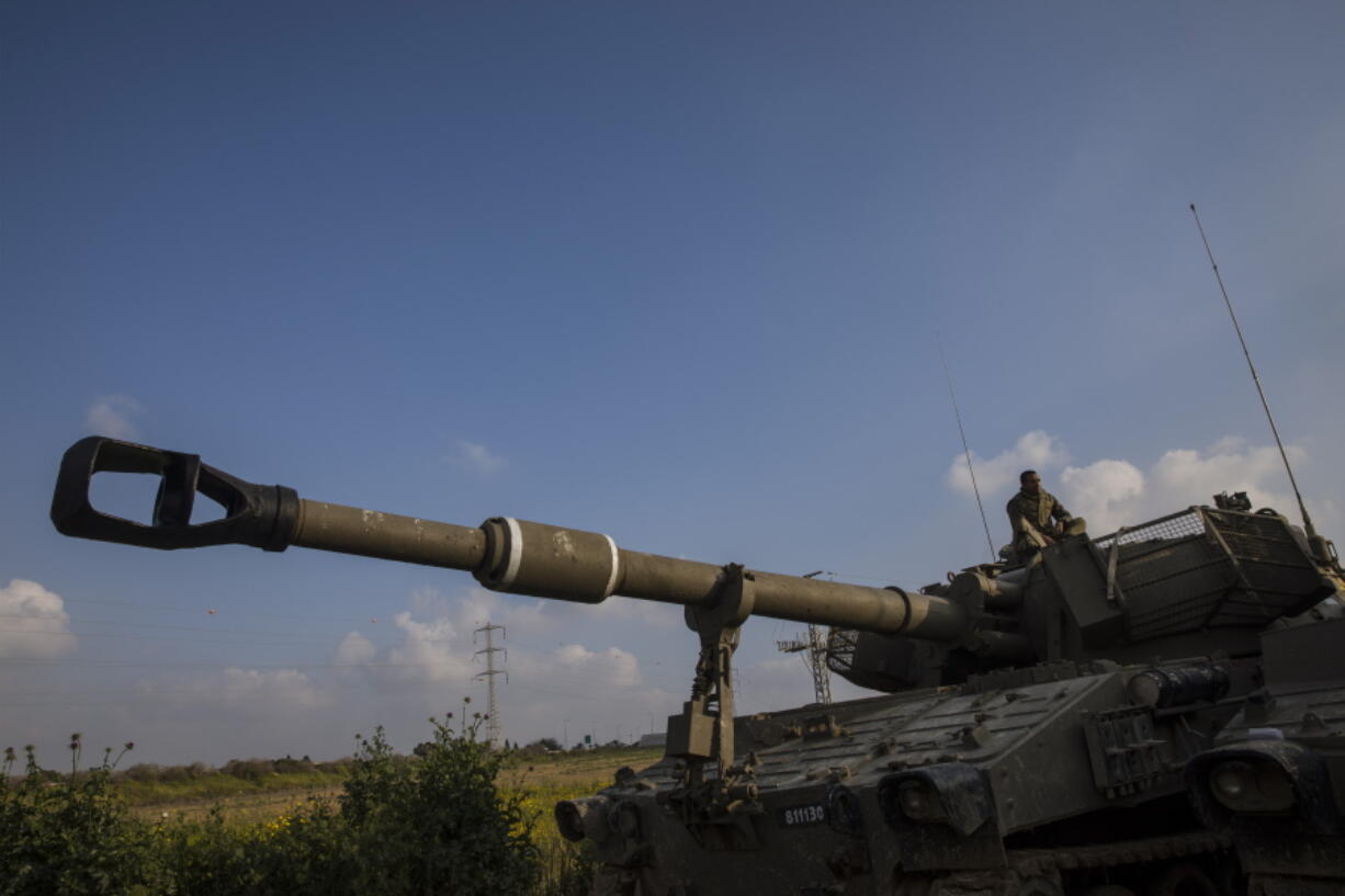 An Israeli soldier sits atop mobile artillery Wednesday in southern Israel near the border with Gaza.