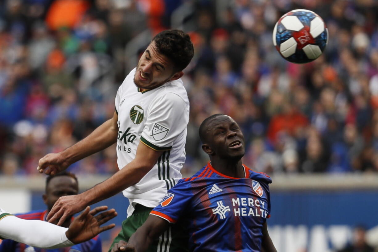 Portland Timbers midfielder Cristhian Paredes, left, heads the ball next to FC Cincinnati forward Kekuta Manneh (31) during the first half of an MLS soccer match Sunday, March 17, 2019, in Cincinnati.