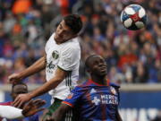 Portland Timbers midfielder Cristhian Paredes, left, heads the ball next to FC Cincinnati forward Kekuta Manneh (31) during the first half of an MLS soccer match Sunday, March 17, 2019, in Cincinnati.