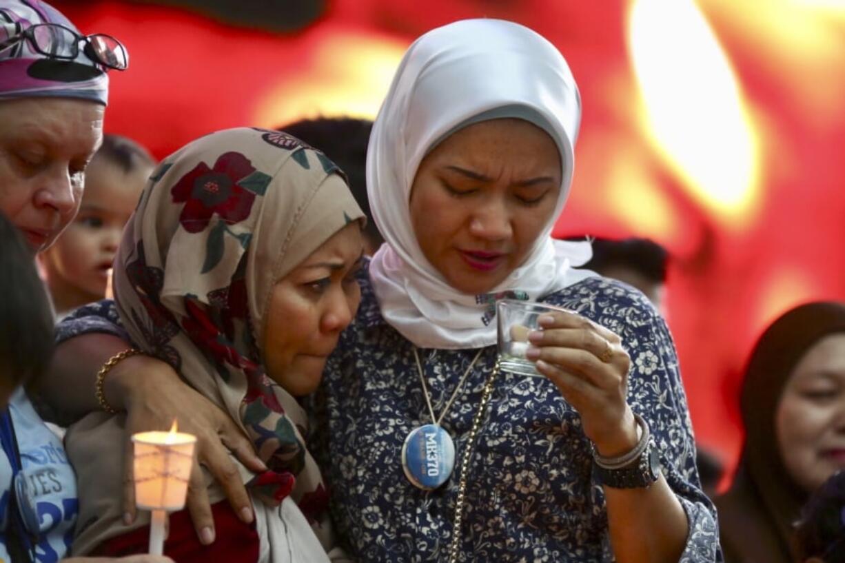 Norazlinda Ayub, left, and Intan Maizura Othaman, wife of an air crew member of Malaysia Airlines Flight 370, embrace each other during the Day of Remembrance for MH370 event in Kuala Lumpur, Malaysia, Sunday. Five years earlier, Flight MH370, a Boeing 777, had gone missing the day before while over the South China Sea with 239 people on board.