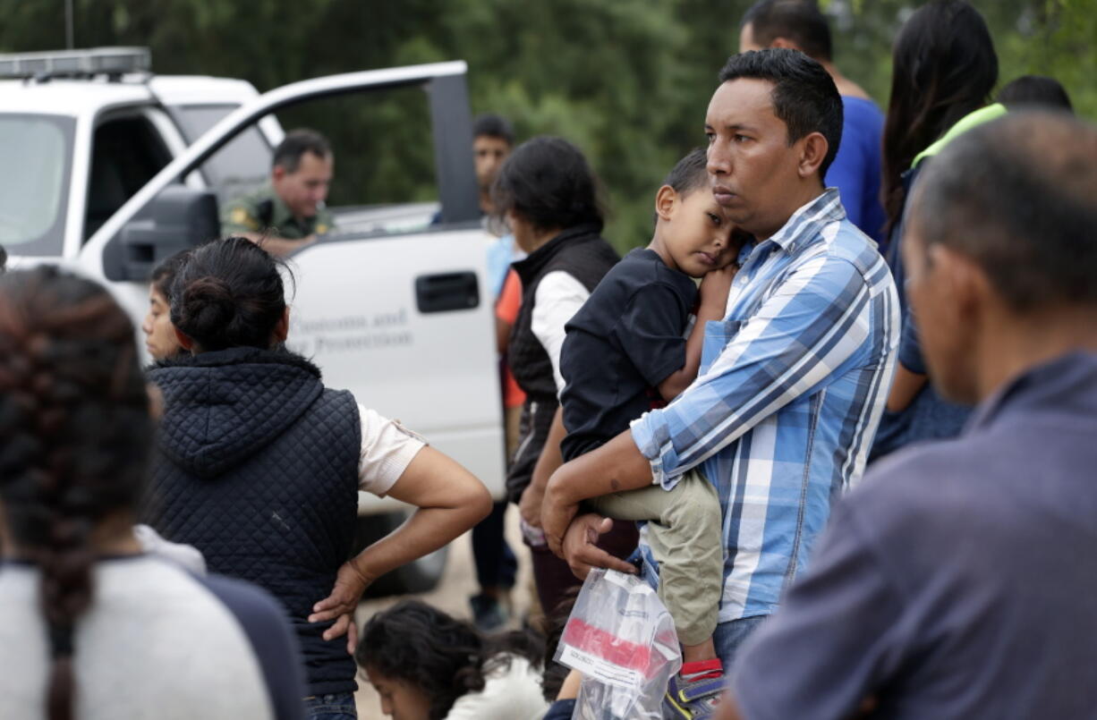 Families who crossed the nearby U.S.-Mexico border near McAllen, Texas, wait for Border Patrol agents to check names and documents on March 14. Immigration authorities say they expect the ongoing surge of Central American families crossing the border to multiply in the coming months.