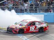 Kyle Busch does a burnout in celebration of winning the NASCAR Cup Series auto race at ISM Raceway, Sunday, March 10, 2019, in Avondale, Ariz.