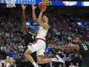 Gonzaga forward Brandon Clarke, center, goes to the basket as Baylor’s Mario Kegler (4) and Mark Vital (11) defend during the second half of a second-round game in the NCAA men’s college basketball tournament Saturday, March 23, 2019, in Salt Lake City.