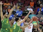 Virginia’s De’Andre Hunter (12) is defended by Oregon’s Ehab Amin (4), Kenny Wooten (14) and Paul White (13) during the first half of a men’s NCAA Tournament college basketball South Regional semifinal game, Thursday, March 28, 2019, in Louisville, Ky. (AP Photo/Timothy D.