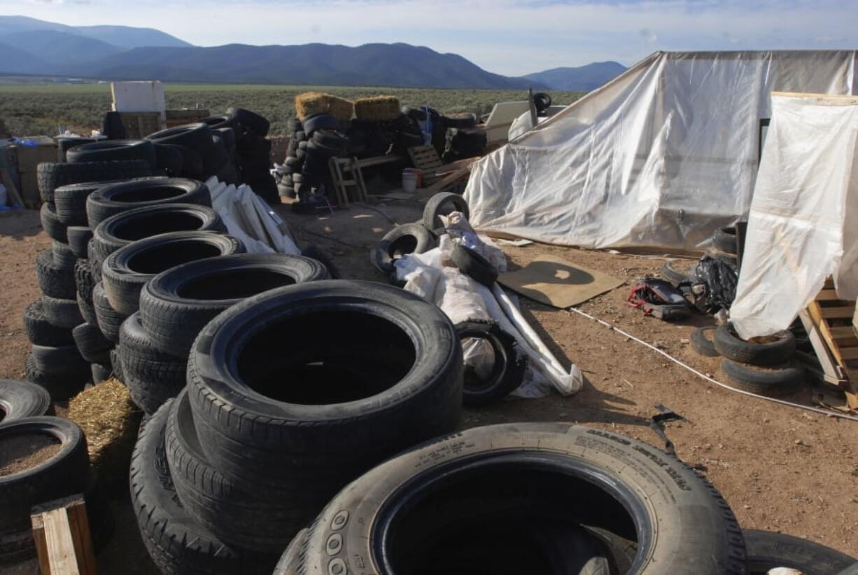 FILE - In this Aug. 10, 2018, file photo, is a makeshift living compound in Amalia, N.M. The five men and women found living in a ramshackle compound in northern New Mexico where a boy was found dead last year have been indicted on federal charges related to terrorism, kidnapping and firearms violations. The U.S. attorney’s office in New Mexico announced the superseding indictment Thursday, March 14, 2019.