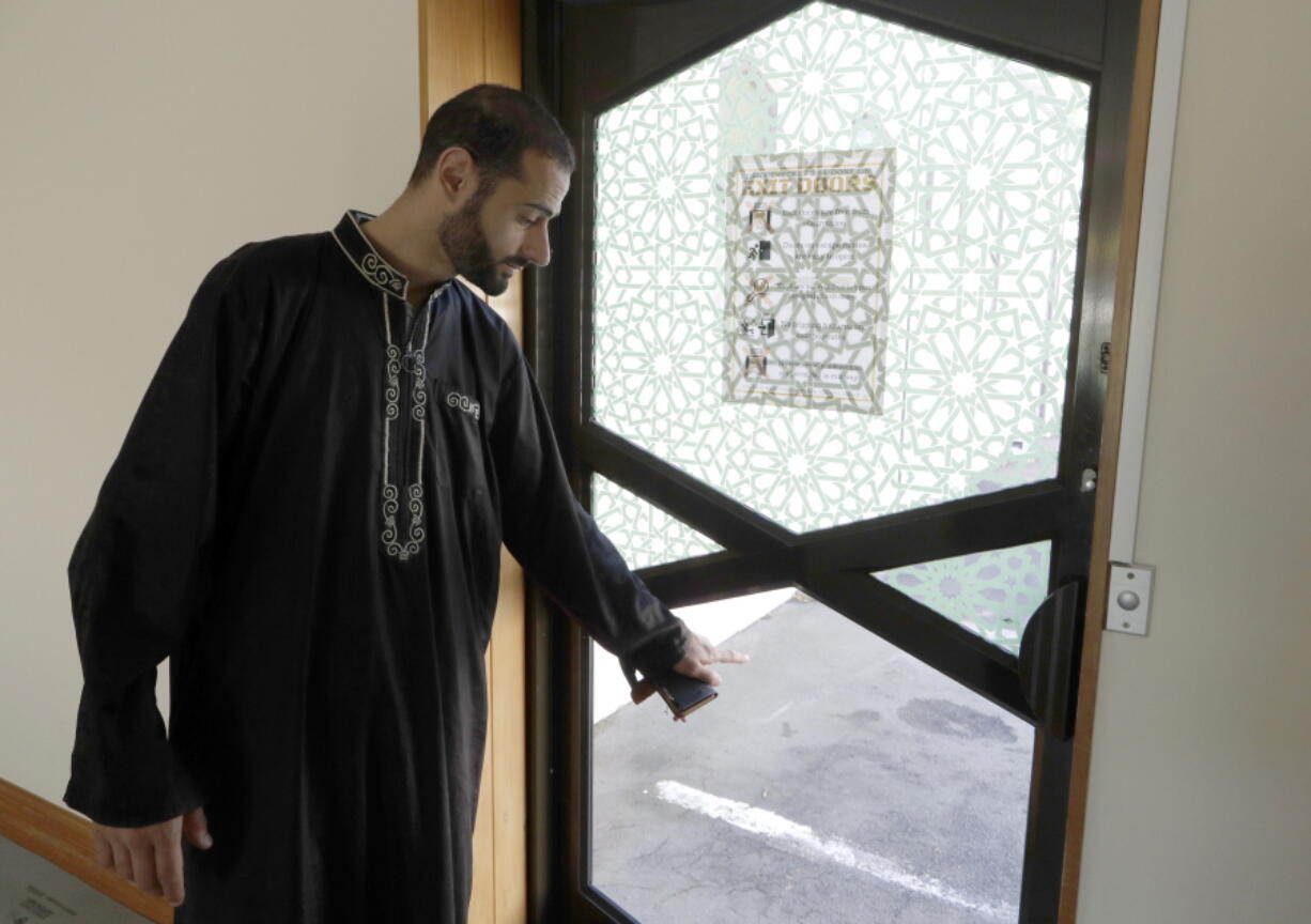 In this March 27, 2019, photo, Al Noor mosque volunteer Khaled Alnobani gestures as he explains his escape through a glass door panel when a gunman burst into the mosque on March 15 in Christchurch, New Zealand.