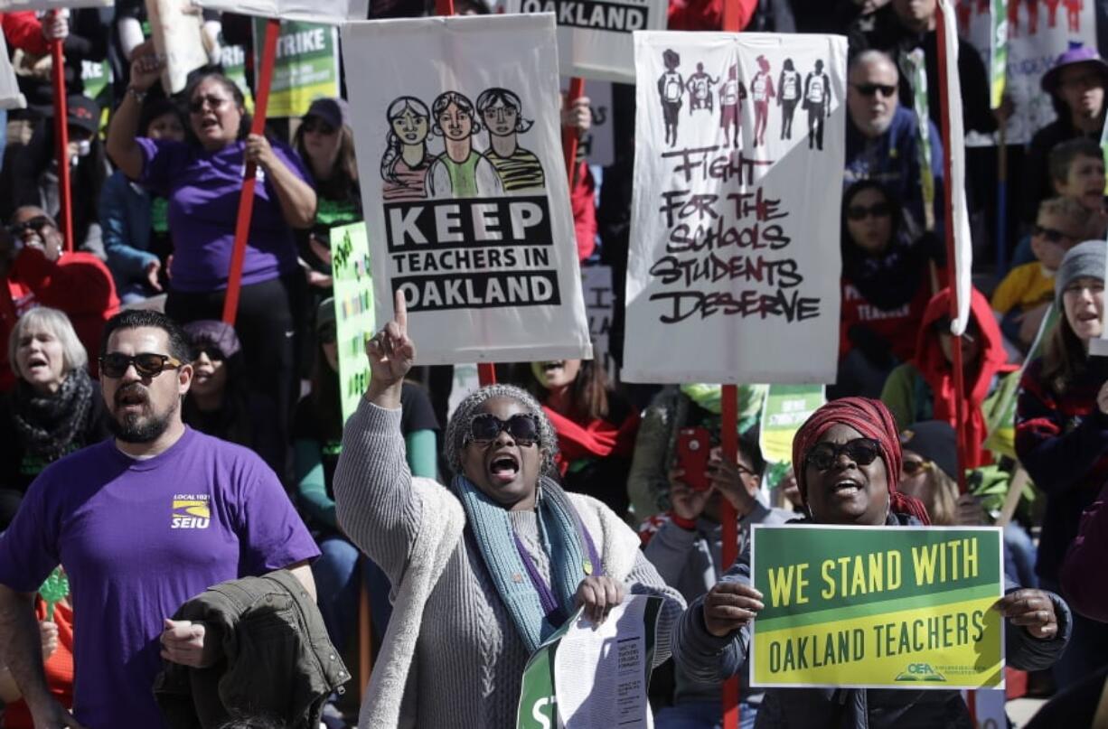 FILE - In this Thursday, Feb. 21, 2019, file photo, teachers, students and supporters rally at Frank Ogawa Plaza in front of City Hall in Oakland, Calif. School leaders and teachers in Oakland have reached a tentative deal to end a week-long strike. The school district said Friday, March 1, 2019, that teachers will receive an 11 percent salary increase plus a one-time 3 percent bonus. Oakland’s 3,000 teachers walked off the job Feb. 21 to demand higher pay, smaller class sizes and more school resources.